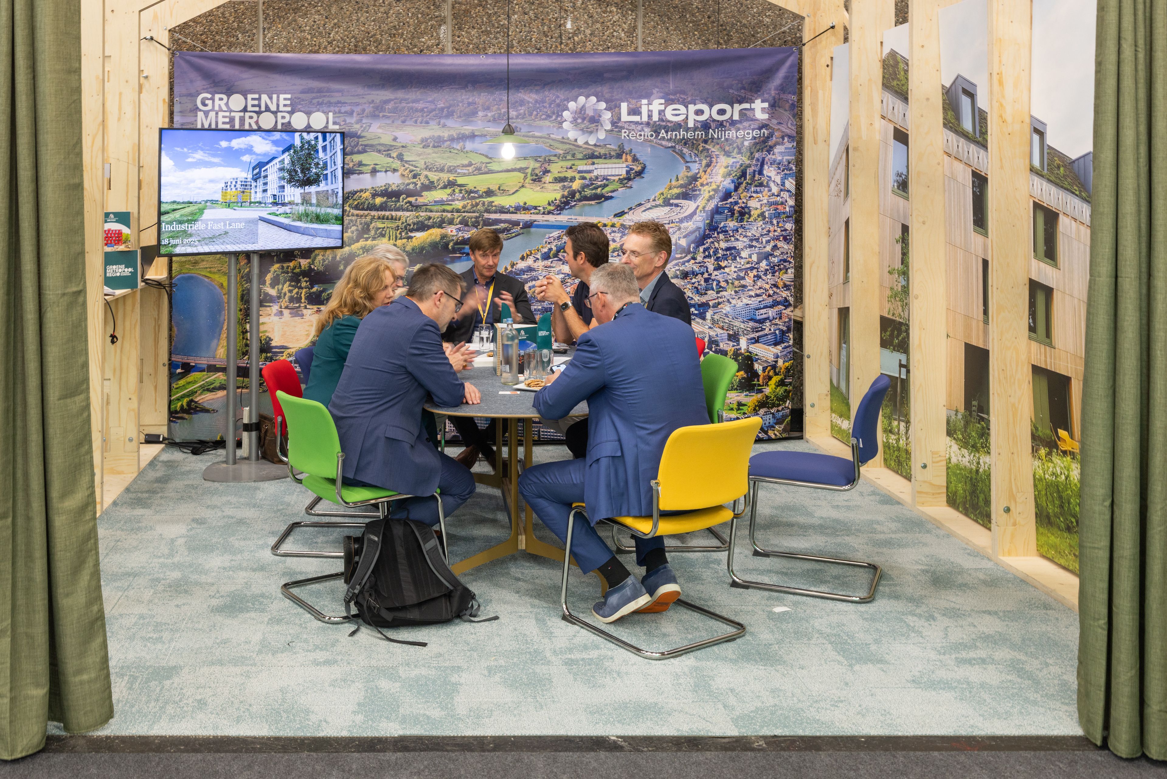 Evenementfotografie Groene Metropool: Groep mensen in gesprek tijdens een evenement, met banners van Lifefort. Joep van Drunen Photography