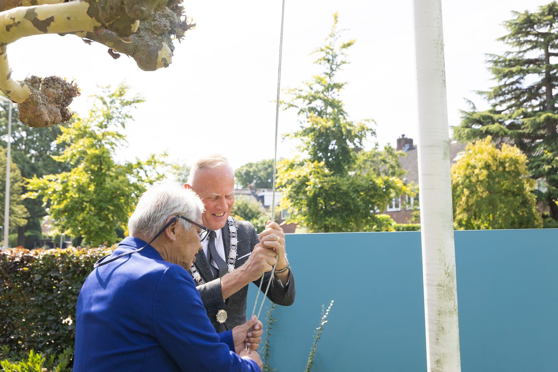 Nusantara Herdenking: Burgemeester en dame hijsen de vlag tijdens de herdenkingsceremonie. Joep van Drunen Photography