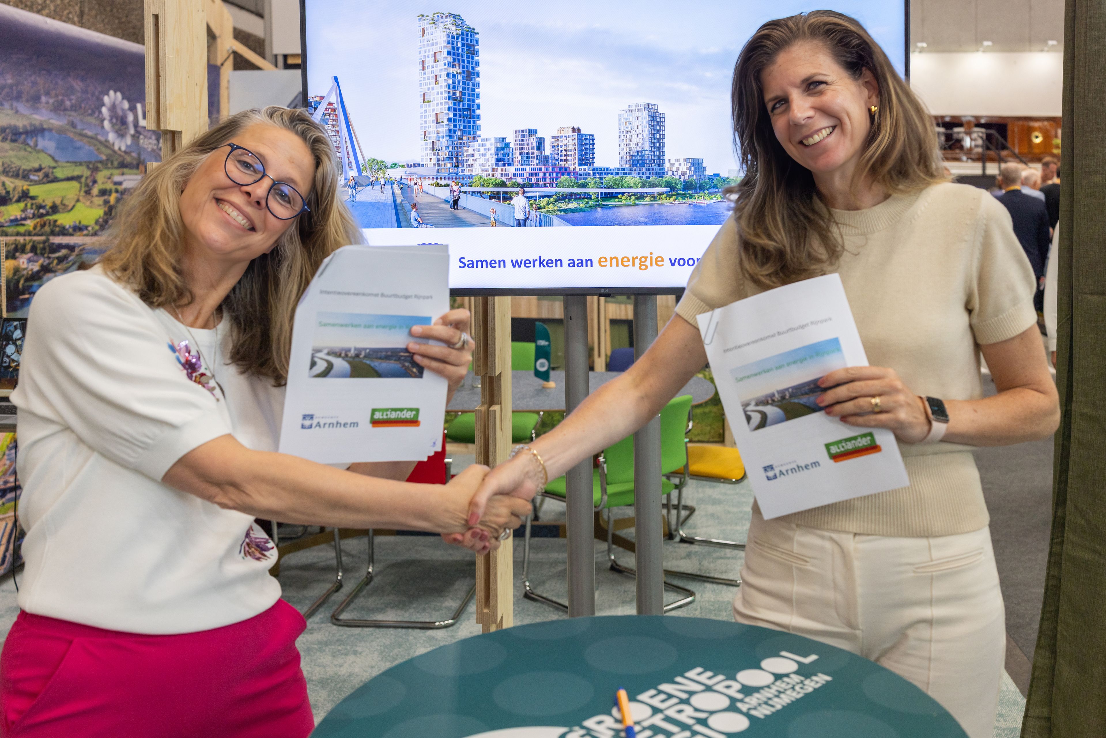 Eventfotografie Groene Metropool: Twee vrouwen schudden handen bij een evenement over duurzame energie in Arnhem. Joep van Drunen Photography