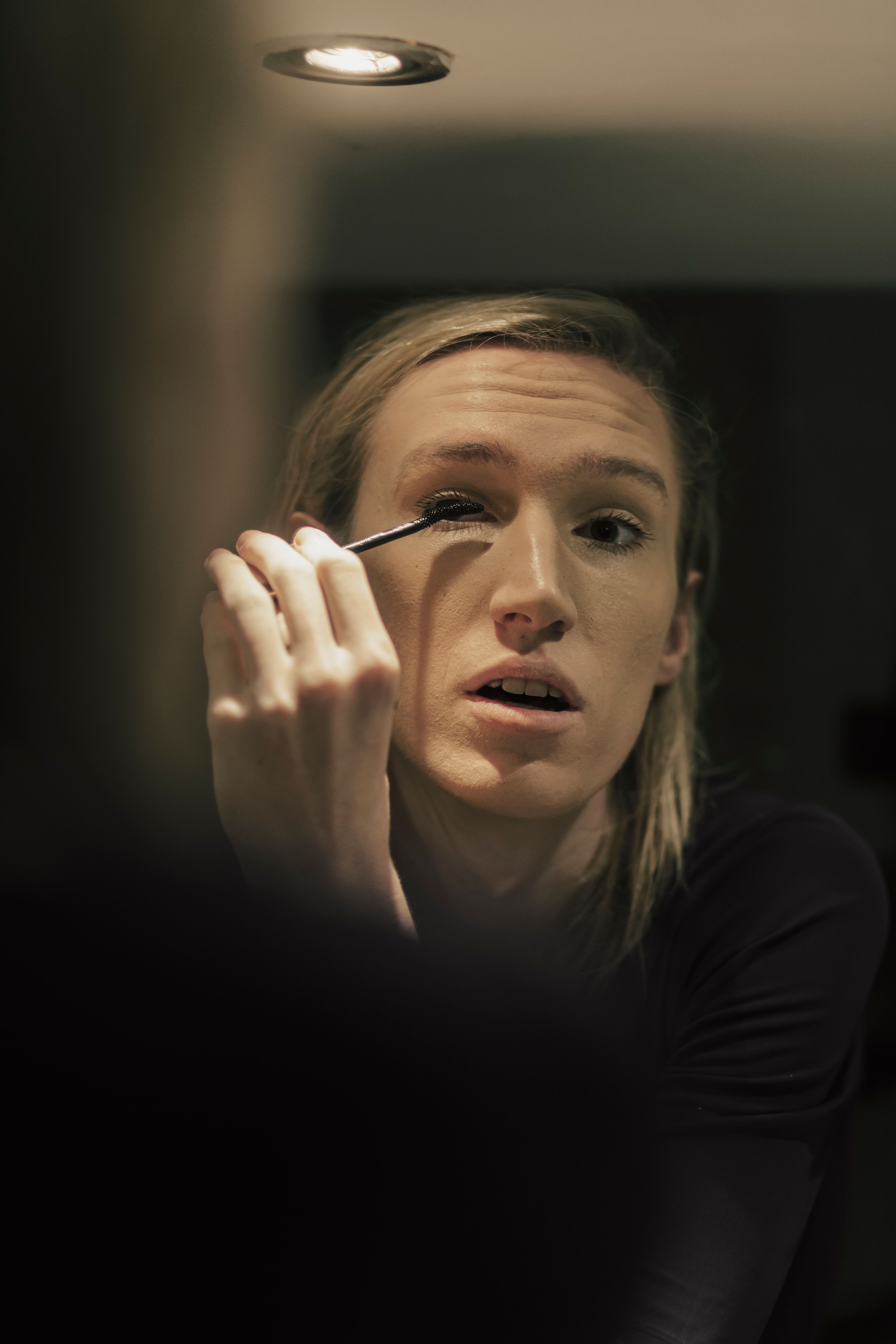 Senna Bodile brengt make-up aan voor de spiegel. Wimper-applicatie detailopname. Joep van Drunen Photography