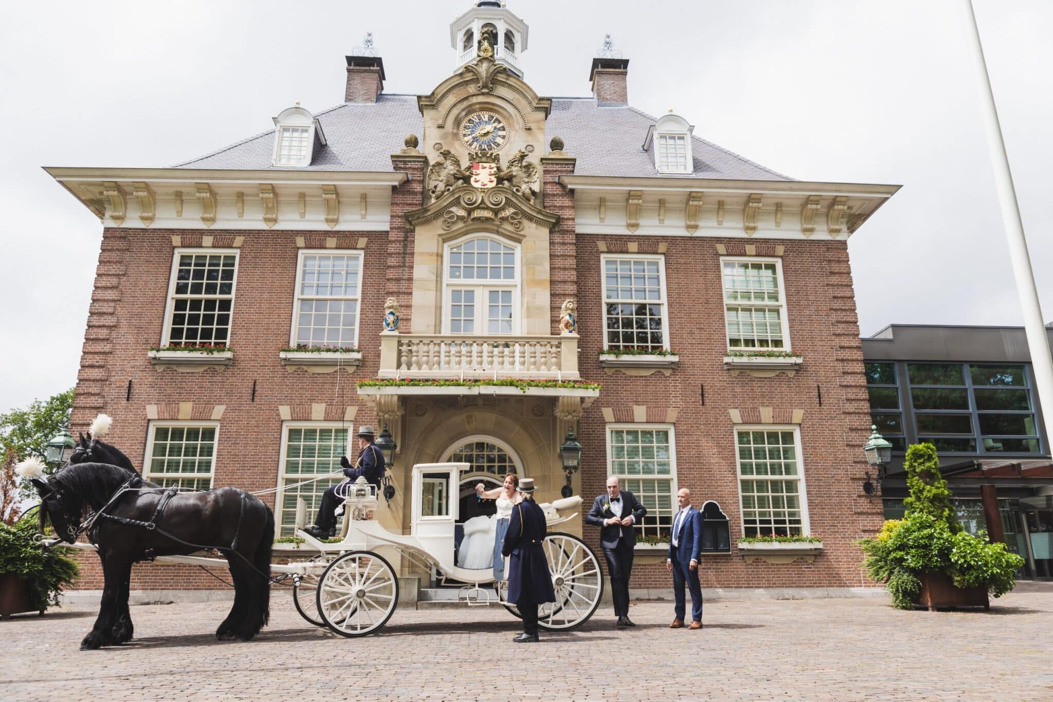 Trouwkoets met paarden voor het stadhuis bij de ceremonie