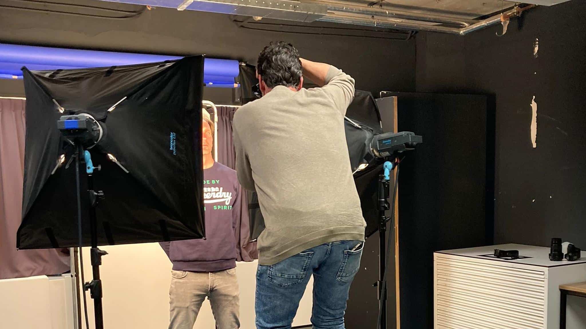 In de studio: fotograaf fotografeert een model met studioverlichting
