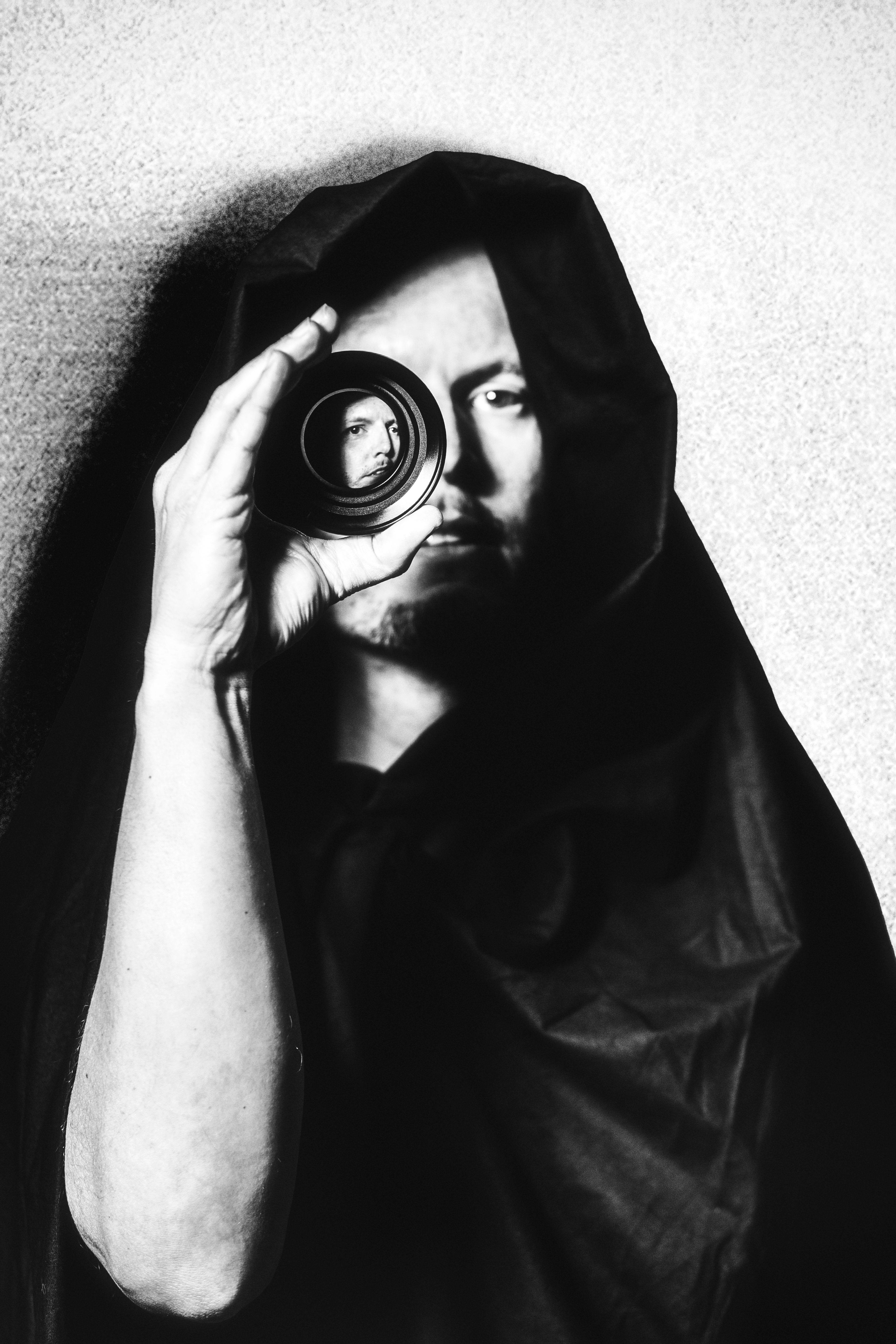 Zwart-wit portretfotografie van Bert Woudt met lens voor oog, creatieve portretfoto in studio. Joep van Drunen Photography