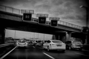 Zwart-wit foto van een autonome auto op de snelweg, documentaire stijl. Snelheidsborden '50'. Joep van Drunen Photography