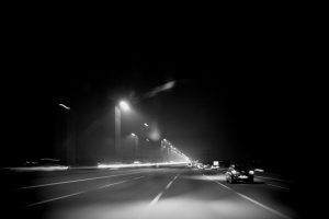 Zwart-wit foto van een snelweg 's nachts, met straatverlichting en auto's in beweging. IMG_8525. Joep van Drunen Photography