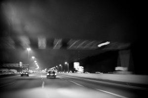 Zwart-wit documentaire foto van een nachtelijke autosnelweg met bewegingsonscherpte. IMG_8526 Joep van Drunen Photography