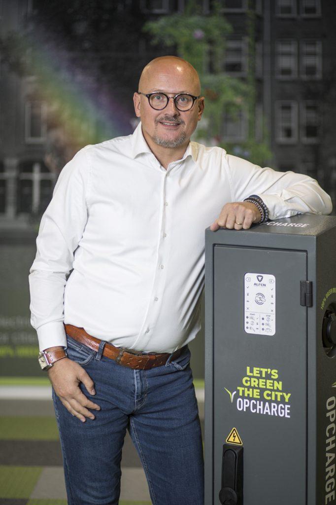 Bedrijfsportret van man bij oplaadpaal. Zakelijk portret voor 'Bedrijfsportretten'. Joep van Drunen Photography.