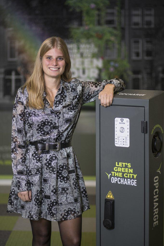 Zakelijk portret van een jonge vrouw bij een Opcharge laadpaal voor elektrische auto's. Bedrijfsportretten Joep van Drunen Photography