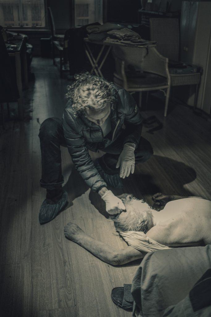 Documentaire foto: Autonoom moment. Persoon met handschoenen onderzoekt lichaam op de vloer. Joep van Drunen Photography