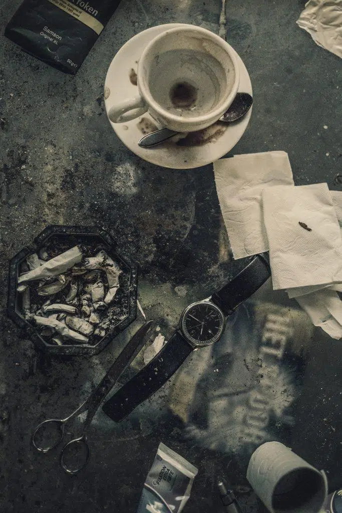 Stilleven van een documentaire maker met een vieze koffiekop, asbak, schaar en horloge. Joep van Drunen Photography