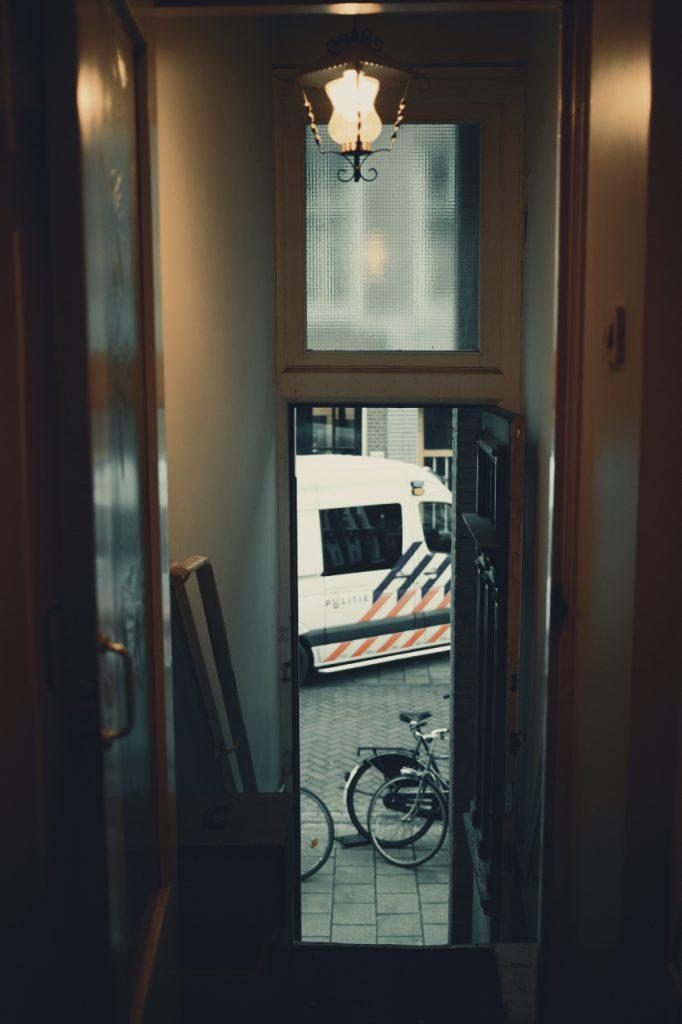 Doorkijkje naar een politieauto in de straat vanaf een autonoom standpunt. Documentaire foto van de politie. Joep van Drunen Photography