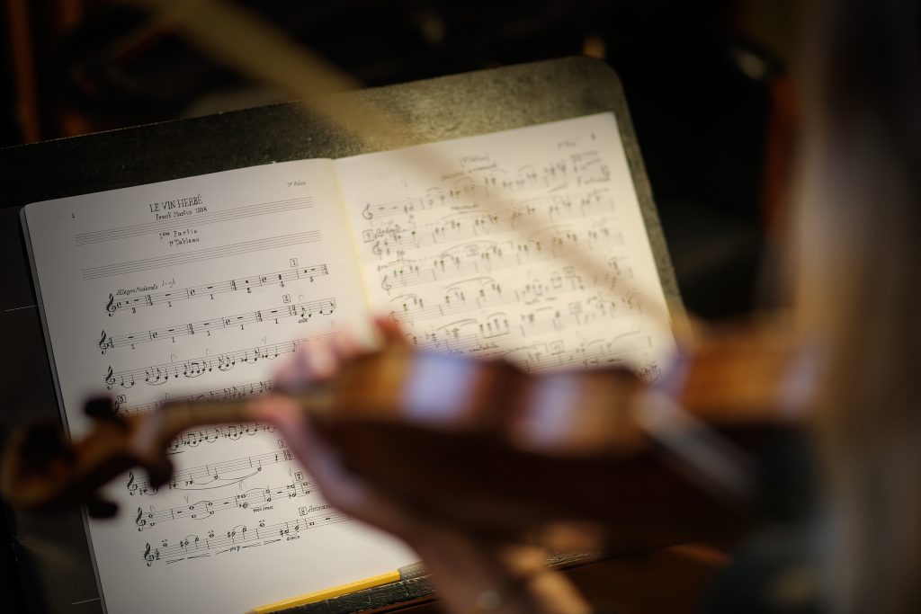 Portretfotografie van viool en bladmuziek IS5A2215. Muzieknoten op bladmuziekstandaard met viool op de voorgrond. Joep van Drunen Photography