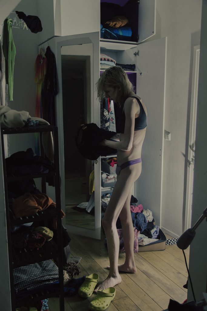 Senna Bodile in een chaotische kamer met kledingkast. Joep van Drunen Photography