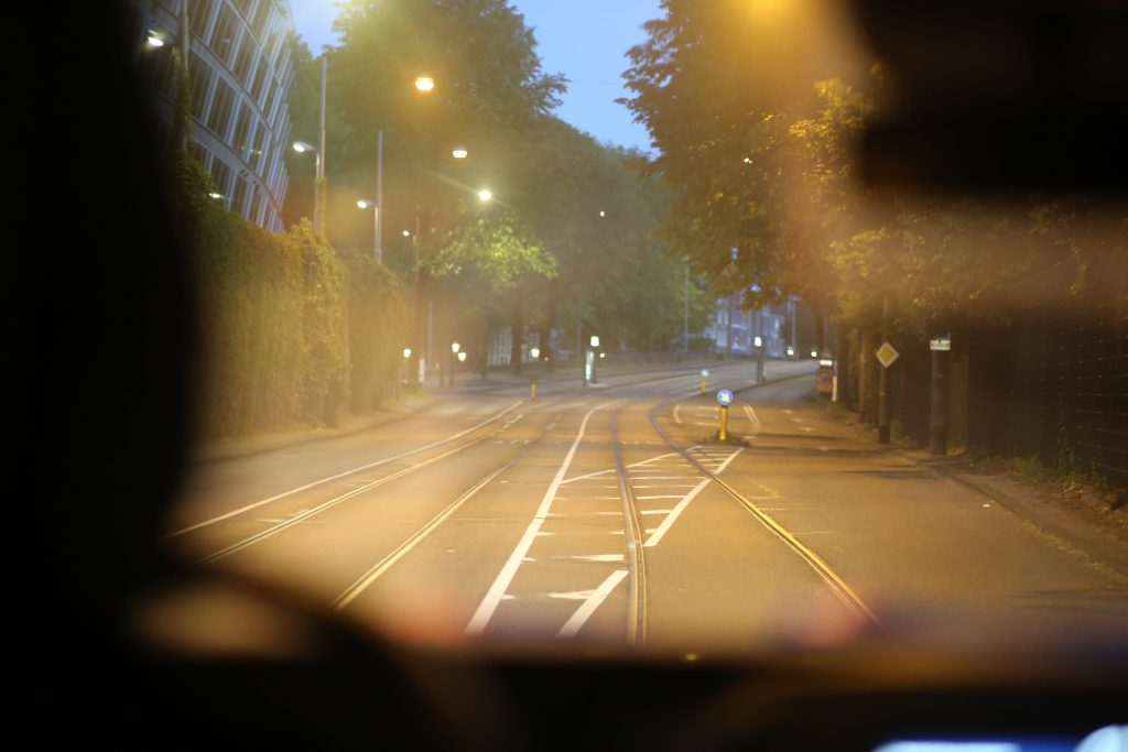Veldwerk: Tramrails en straatbeeld in de avond, gezien vanuit een voertuig. Joep van Drunen Photography