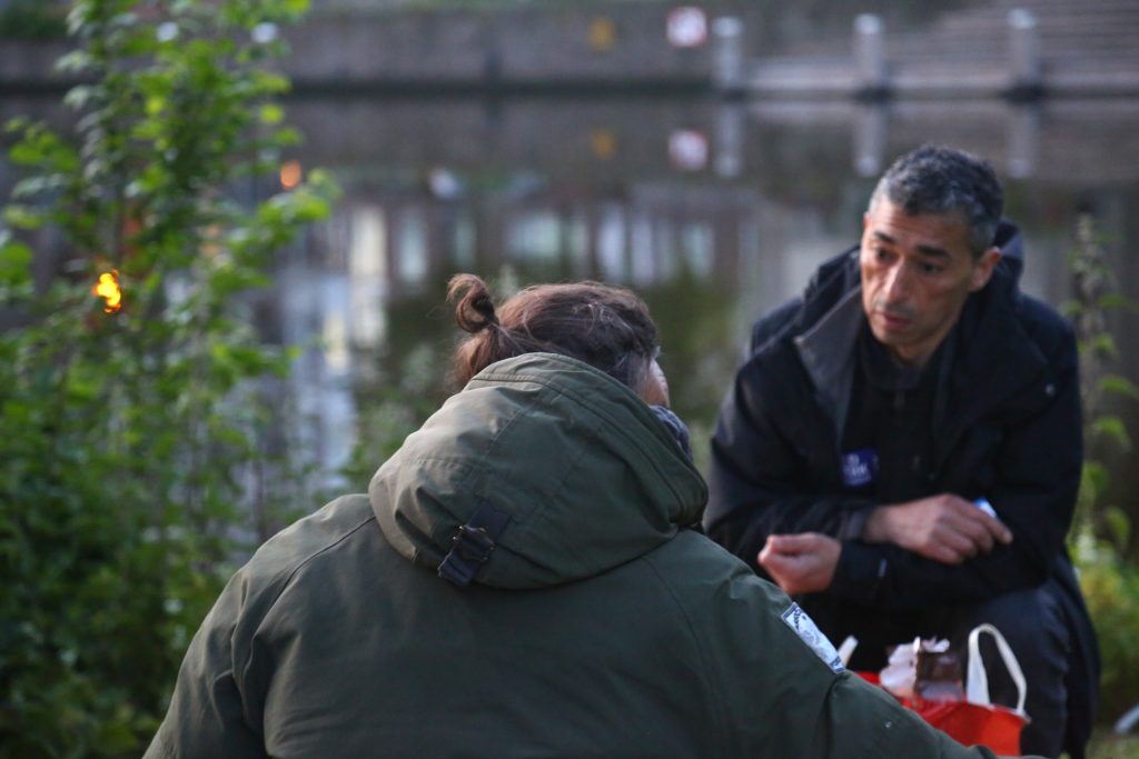 Veldwerk foto van twee mensen in gesprek bij waterkant, buiten. Joep van Drunen Photography
