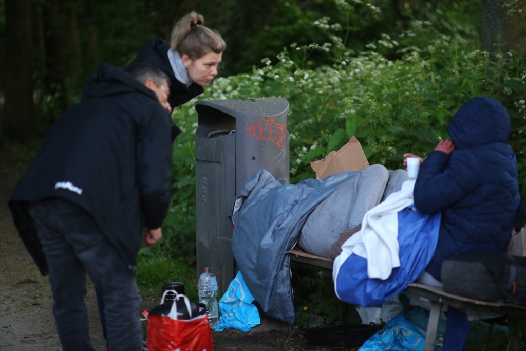 Veldwerk: Mensen bij een bankje met spullen en een persoon onder een deken in het park. Joep van Drunen Photography