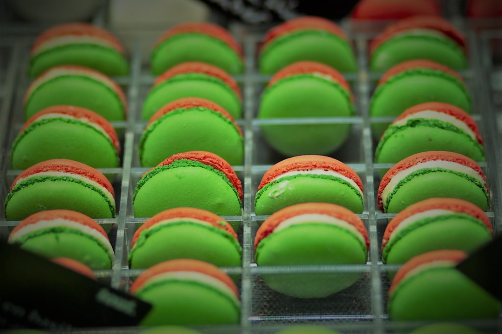 Groene en oranje macarons in een display. Eventfotografie lekkernijen, zoet gebak. Joep van Drunen Photography