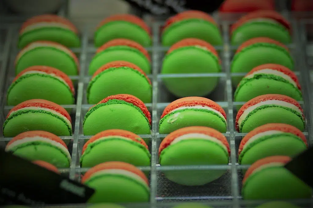 Groene en oranje macarons in een display. Eventfotografie lekkernijen, zoet gebak. Joep van Drunen Photography