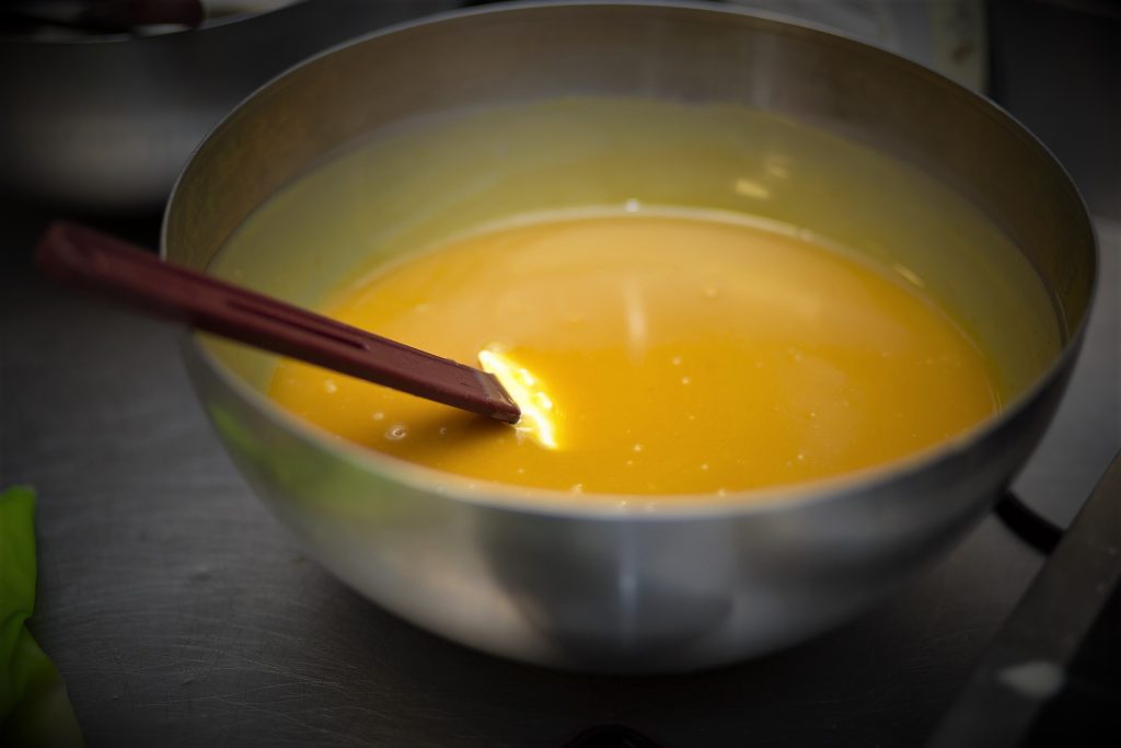 Eventfotografie: Roestvrijstalen kom met gele vloeistof en spatel, gefotografeerd in 2022. Joep van Drunen Photography