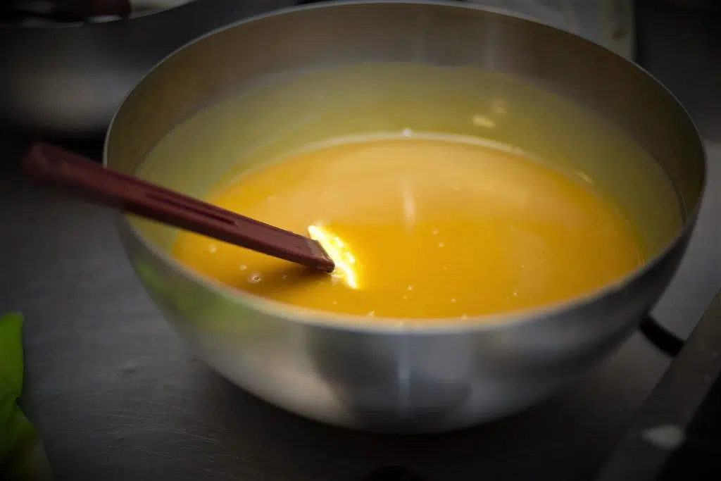 Eventfotografie: Roestvrijstalen kom met gele vloeistof en spatel, gefotografeerd in 2022. Joep van Drunen Photography