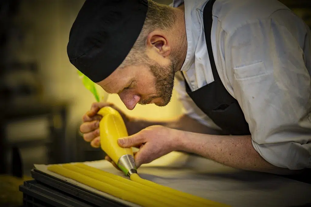 Eventfotografie: Banketbakker spuit deeg op een bakplaat. Culinaire fotografie. Joep van Drunen Photography