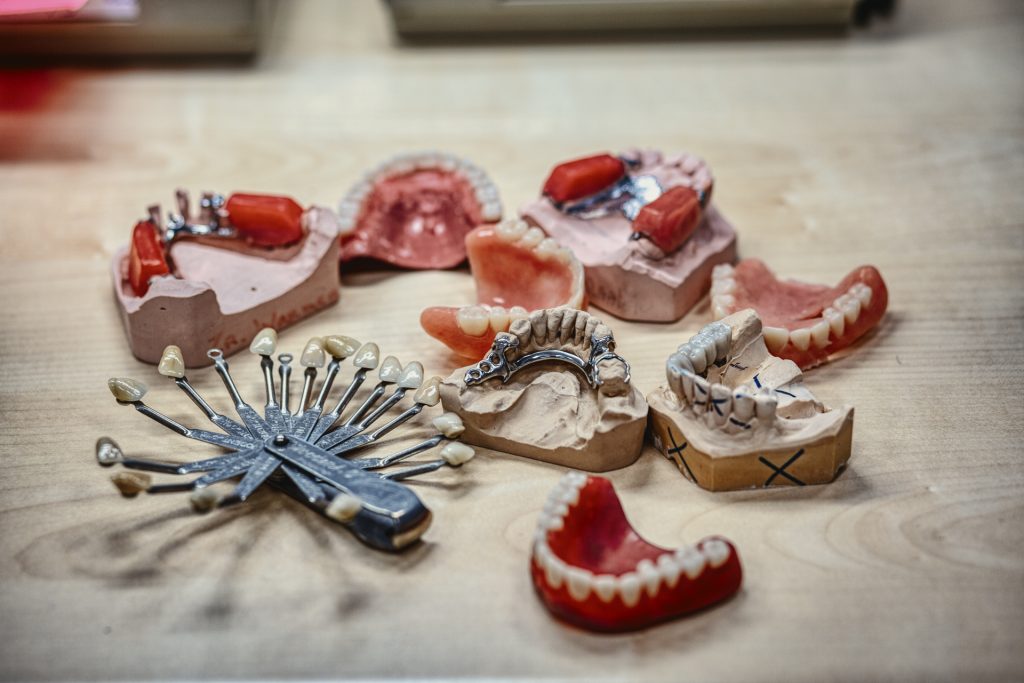 Eventfotografie: Protheses en tandkleurenwaaier op een tafel. Verschillende modellen voor gebitsprotheses. Joep van Drunen Photography