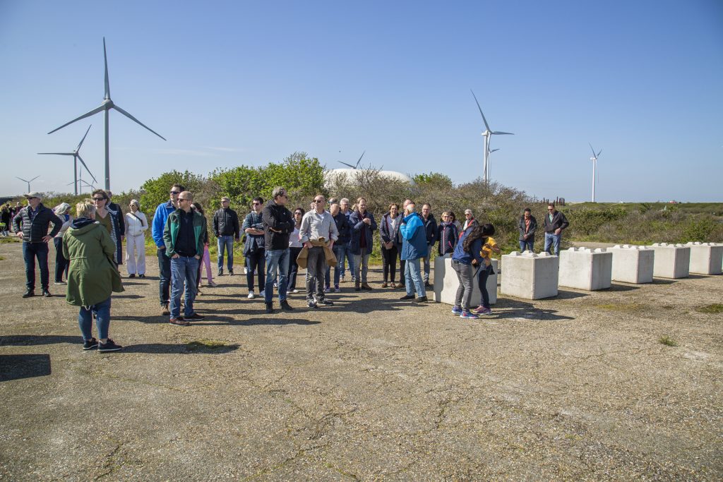 Groep mensen bij windmolens en betonnen blokken. IS5A4194 Joep van Drunen Photography