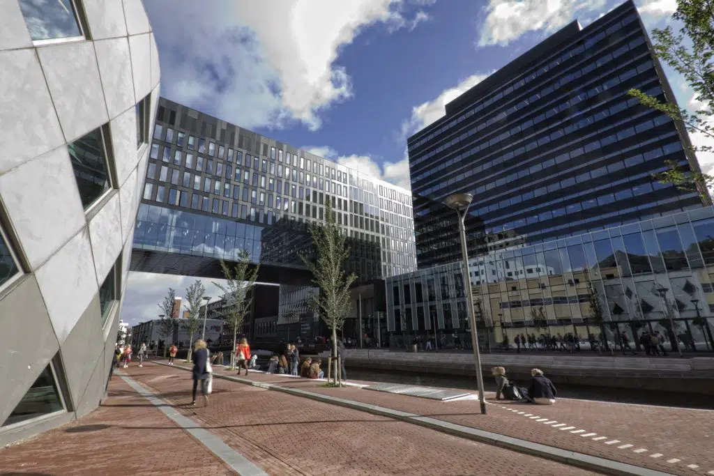 Exterieur van de Universiteit van Amsterdam (UvA) gebouwen met gracht en mensen. Moderne architectuur in Amsterdam. Joep van Drunen Photography