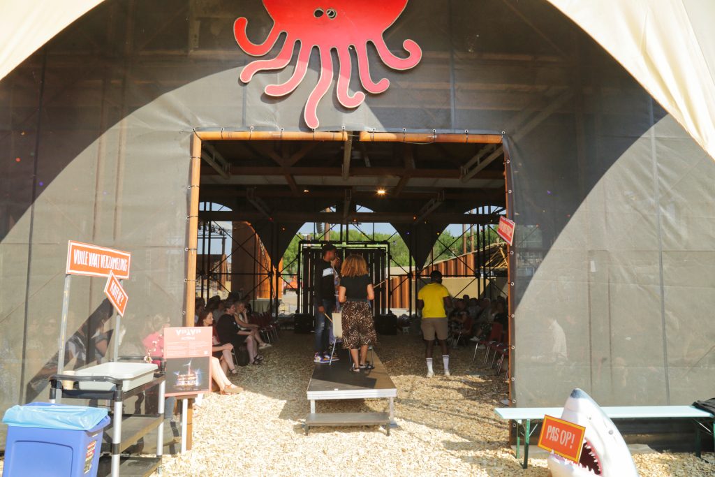 Evenementenlocatie met publiek en podium onder een rode octopus, Joep van Drunen Photography