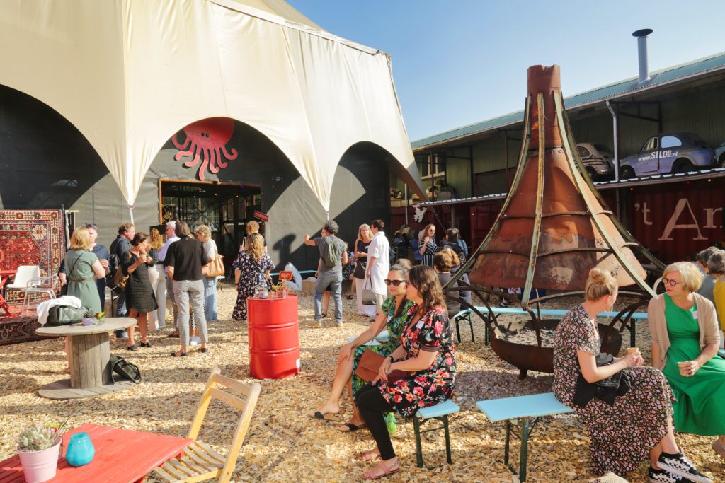 Evenement bij Silo in Leuven, Nederland. Mensen verzameld buiten, tent met octopus logo, en decoratieve elementen. Joep van Drunen Photography