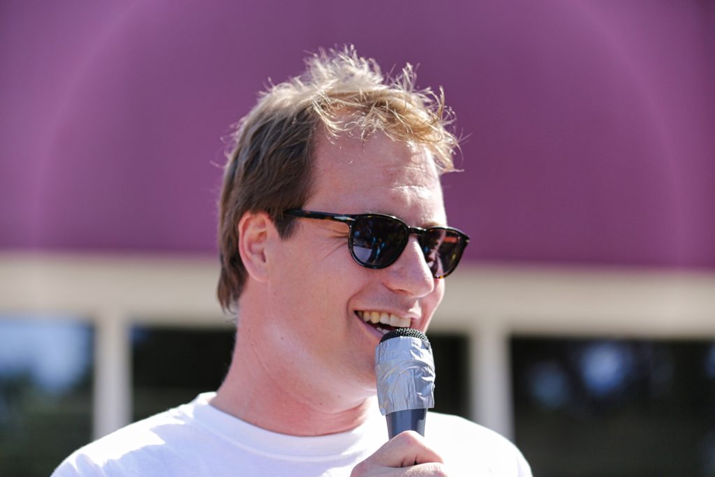 Man met zonnebril spreekt in microfoon, evenement of presentatie. Joep van Drunen Photography