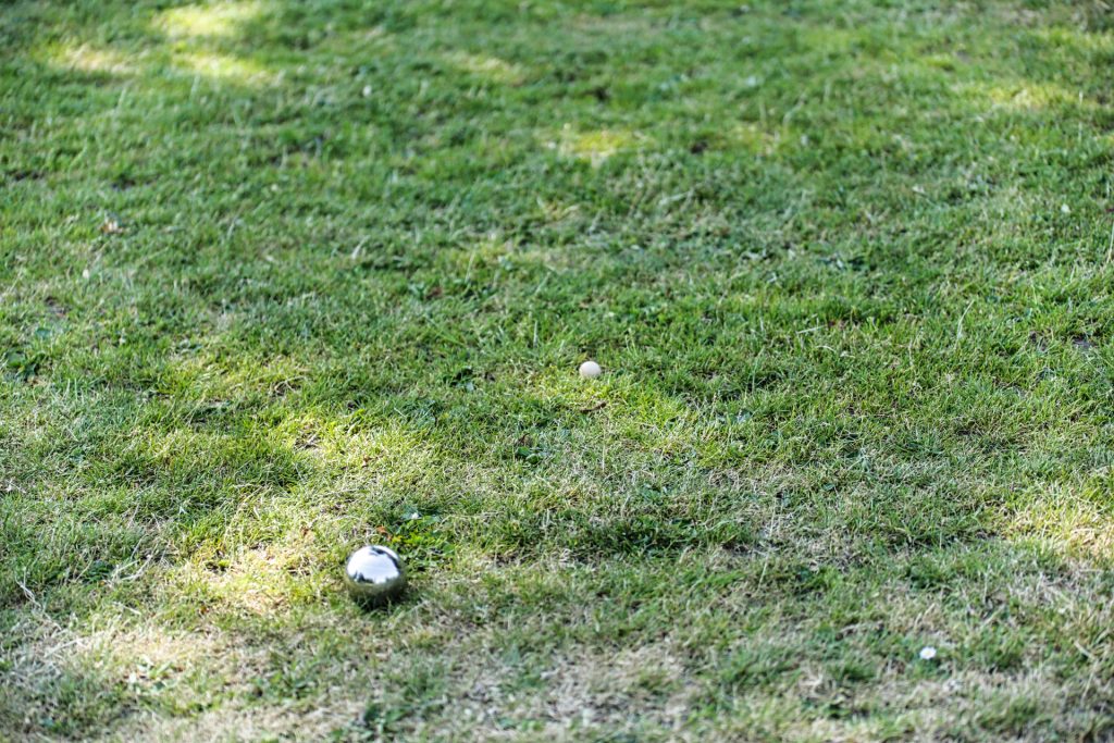 Bocce ballen op groen grasveld, klaar voor een spel petanque in de zon. Zomers buitenspel. Joep van Drunen Photography