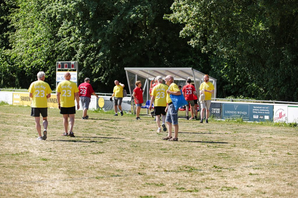 Groep mensen in sportkleding op een veld tijdens een evenement. Gezelligheid en sportiviteit. Joep van Drunen Photography