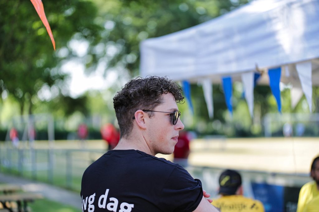 Portret van man met zonnebril op evenement, buitenshuis. Zijaanzicht, ontspannen sfeer. Joep van Drunen Photography