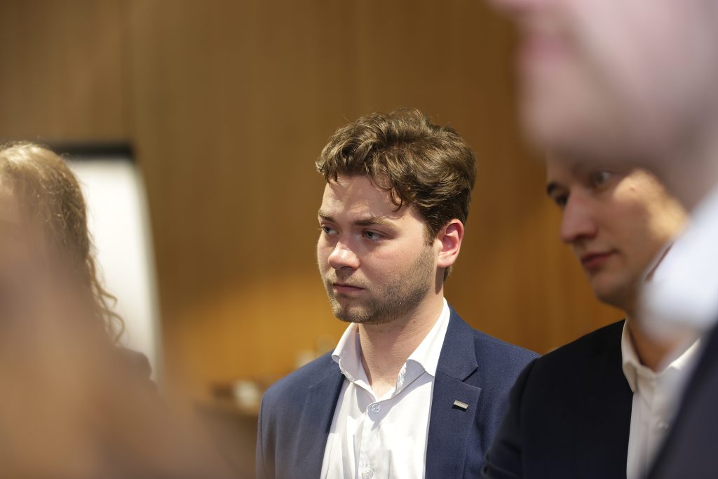 Eventfotografie: Man in pak tijdens evenement. Professionele event fotograaf IS5A5164 legt moment vast. Joep van Drunen Photography