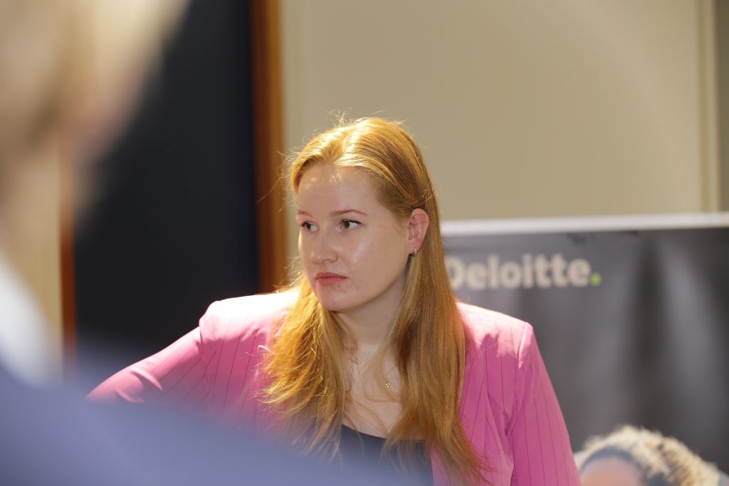 Eventfotografie: Vrouw met rode haren in roze blazer bij een evenement van Deloitte. IS5A5176. Joep van Drunen Photography