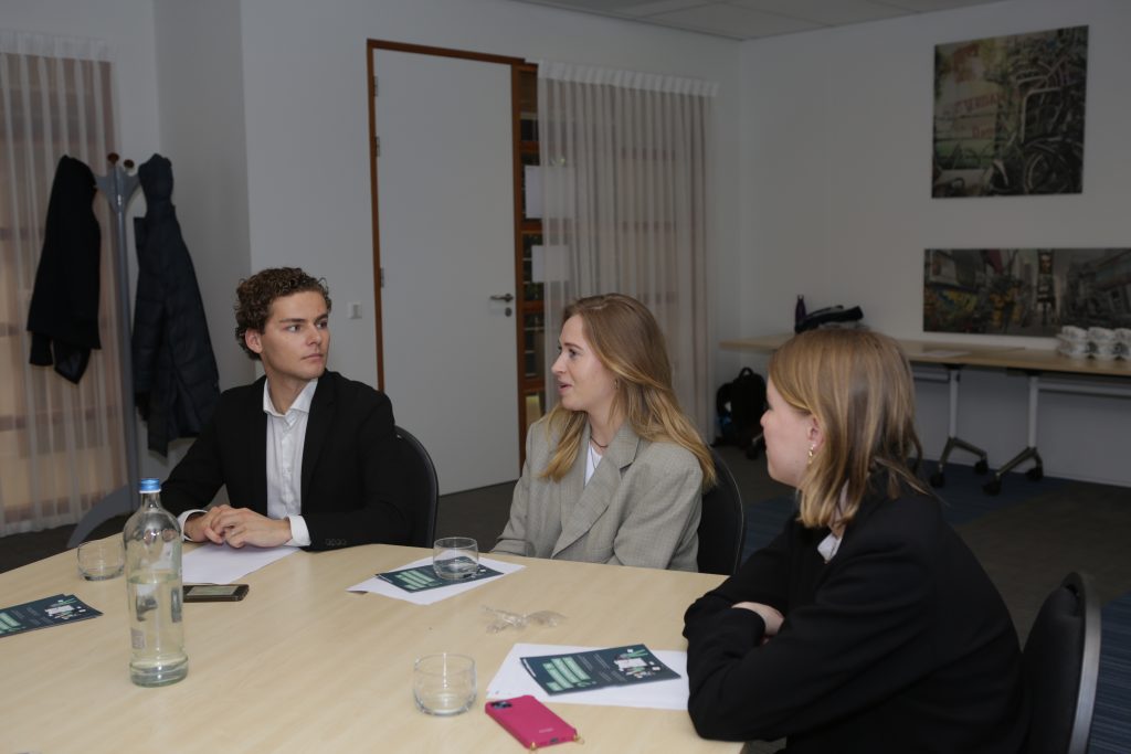 Eventfotografie: Groepsfoto van drie jonge mensen in gesprek tijdens een evenement. IS5A5304. Joep van Drunen Photography
