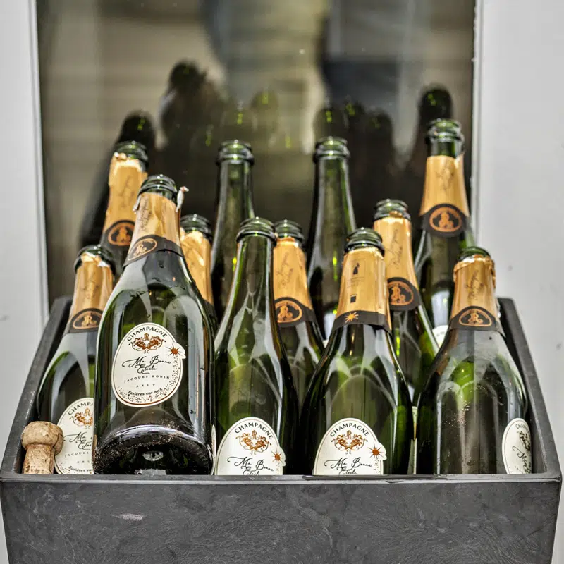 Event photography: A bin full of empty champagne bottles from Mo Bonne Étoile, photographed by Joep van Drunen Photography.