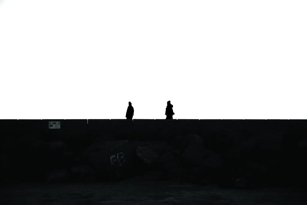 Vrije fotografie van twee mensen als silhouetten op een muur, zwart-wit foto. Joep van Drunen Photography