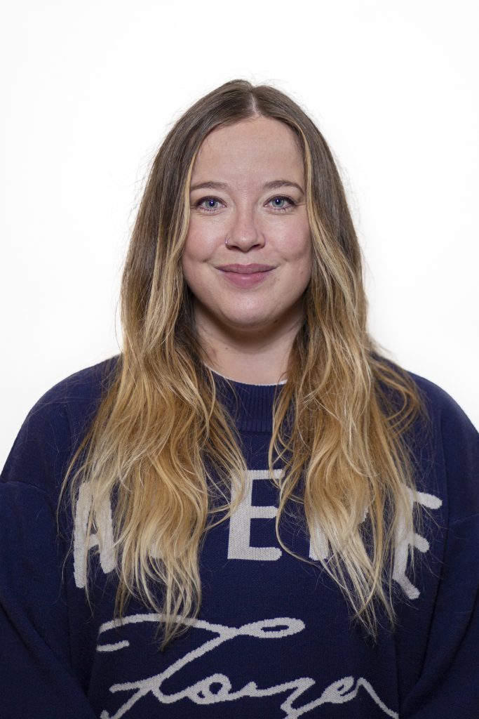 Portretfotografie van een jonge vrouw met blond haar en blauwe ogen, gekleed in een blauwe trui. Joep van Drunen Photography