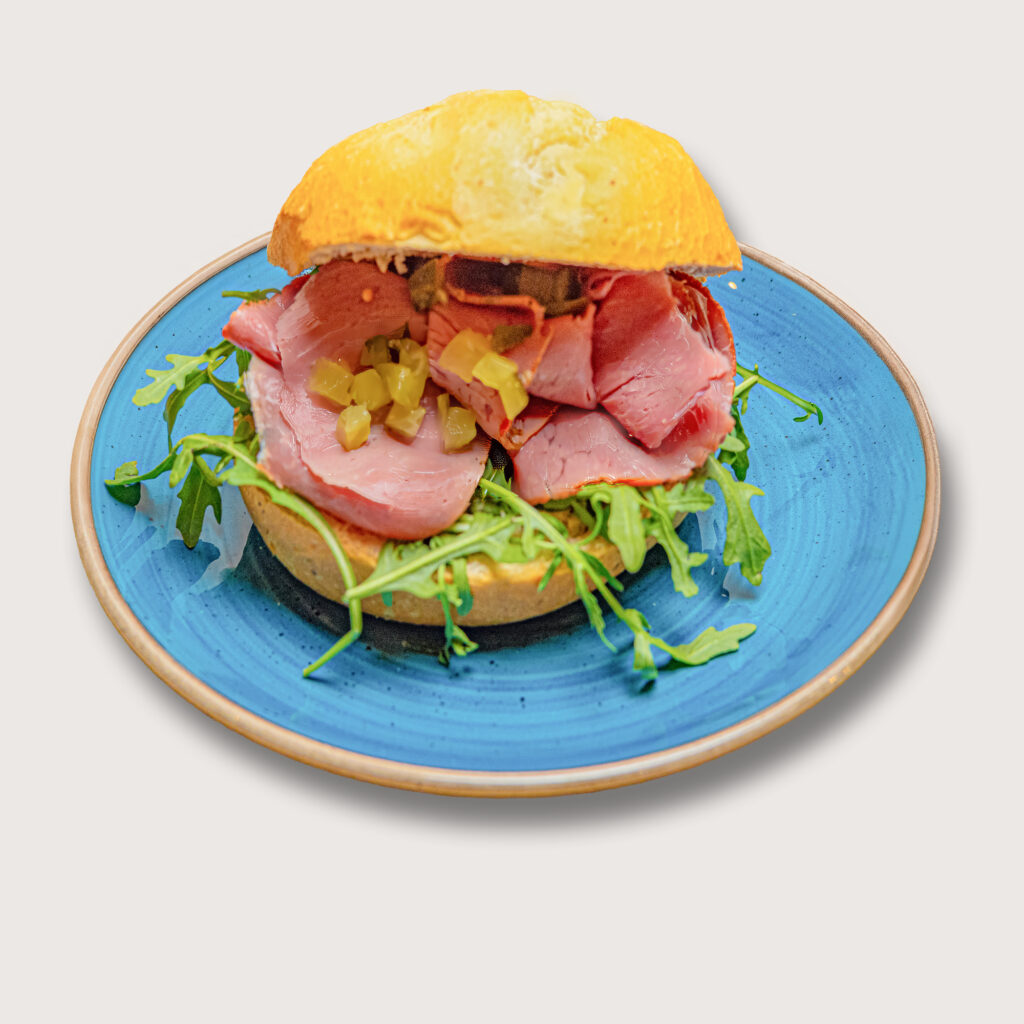 Productfotografie: Broodje met vleeswaren, rucola en augurk op een blauw bord. Joep van Drunen Photography