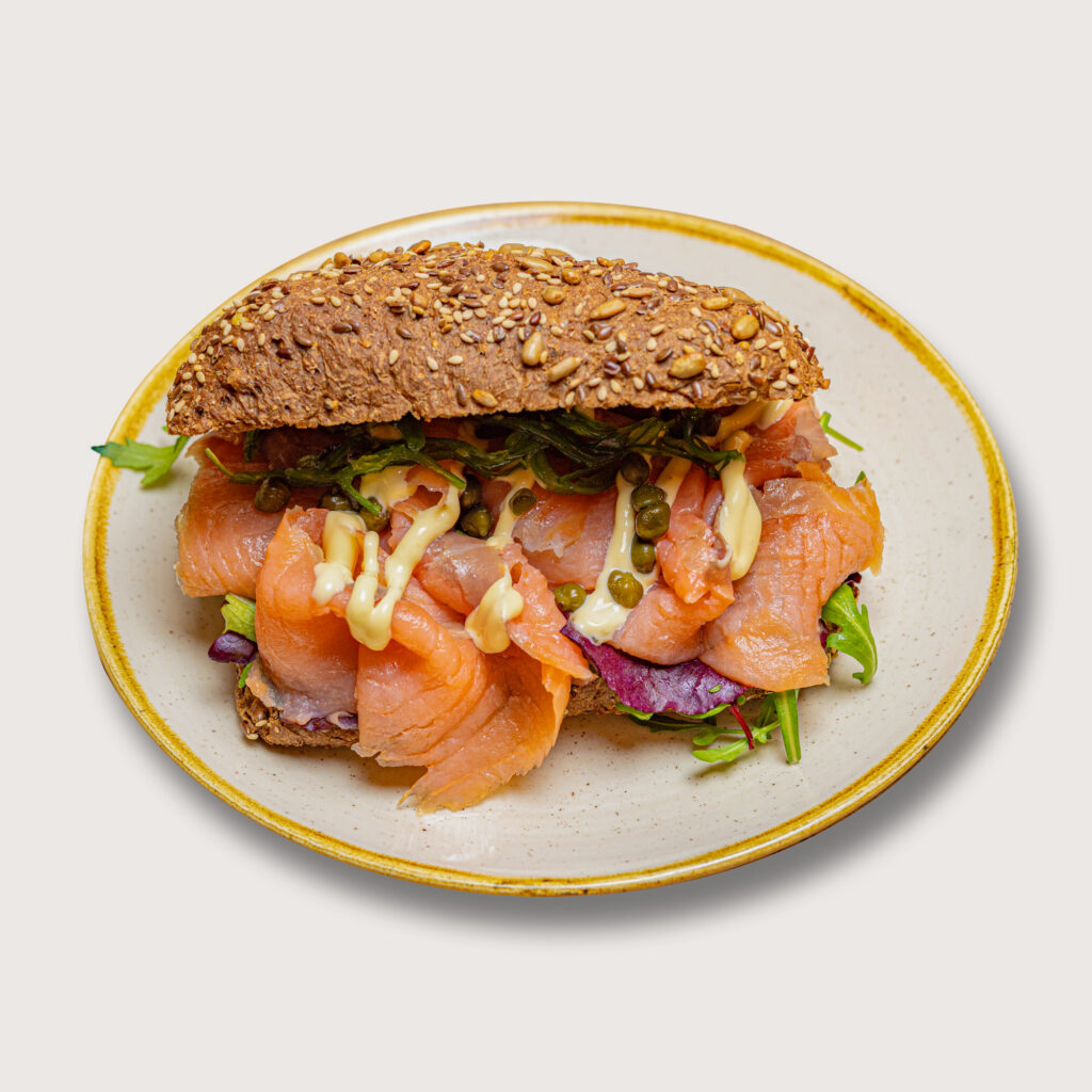 Productfotografie: Broodje belegd met zalm, sla, kappertjes en saus op een bord. Heerlijk broodje! Joep van Drunen Photography
