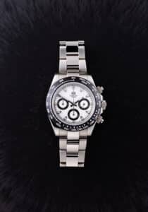 Productfotografie van een zilverkleurig Timery horloge met witte wijzerplaat en zwarte details, liggend op een zwarte achtergrond. Joep van Drunen Photography