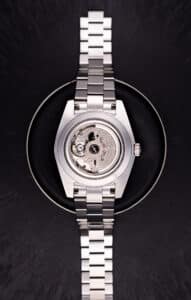 Productfotografie van een zilverkleurig horloge met zichtbaar uurwerk op een zwarte achtergrond. JVD_9338 productfoto Joep van Drunen Photography