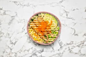 Productfotografie: Een kleurrijke poké bowl met avocado, mais, en edamame op een marmeren achtergrond. Joep van Drunen Photography