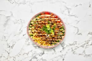 Productfotografie: kleurrijke bowl met mais, tomaat, en saus op een marmeren achtergrond. Joep van Drunen Photography