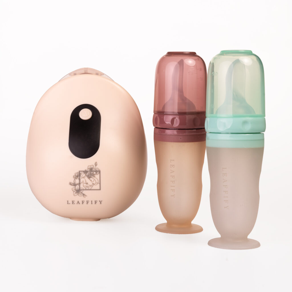 Productfotografie van LEAFFIFY babyflessen en een apparaat, roze en groen, op een witte achtergrond. Joep van Drunen Photography