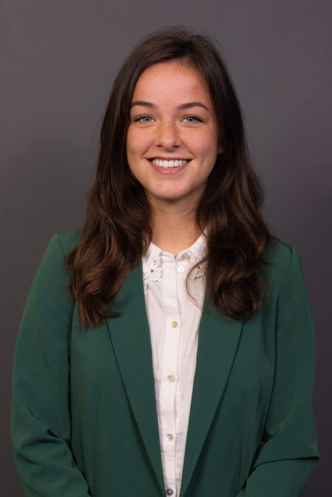 Zakelijk portret van een lachende vrouw in groene blazer. Professionele bedrijfsportretten.