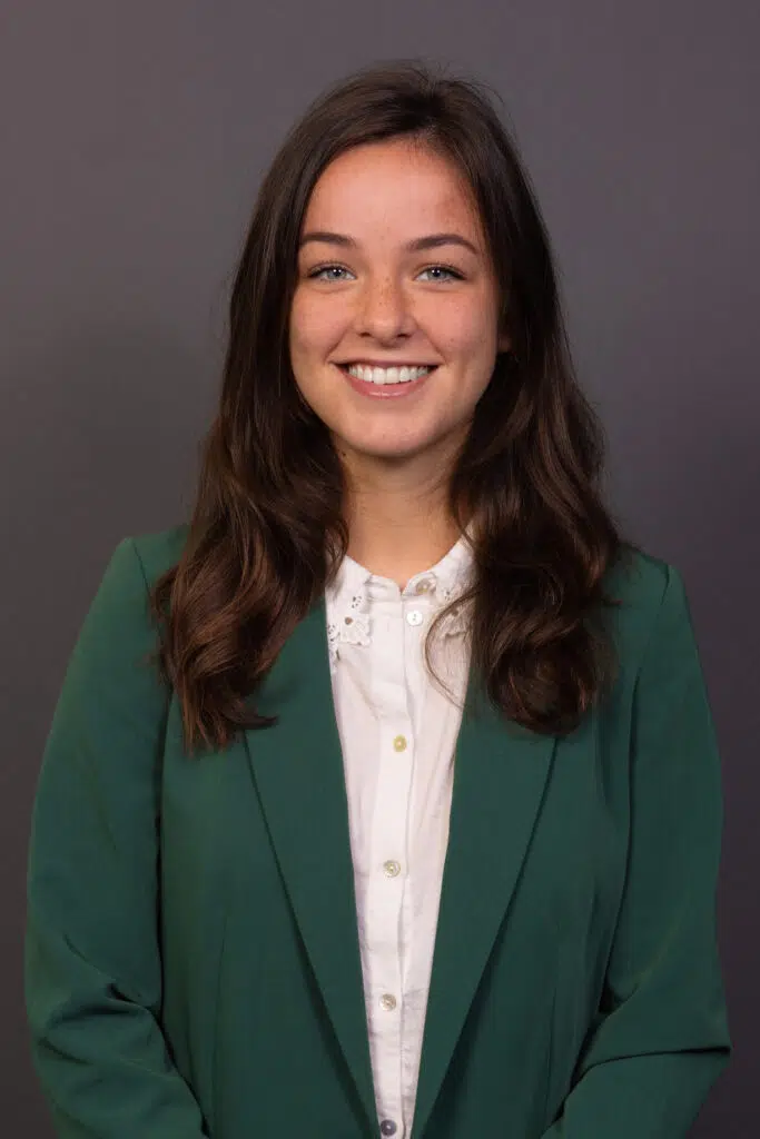 Zakelijk portret van een lachende vrouw in groene blazer. Professionele bedrijfsportretten.