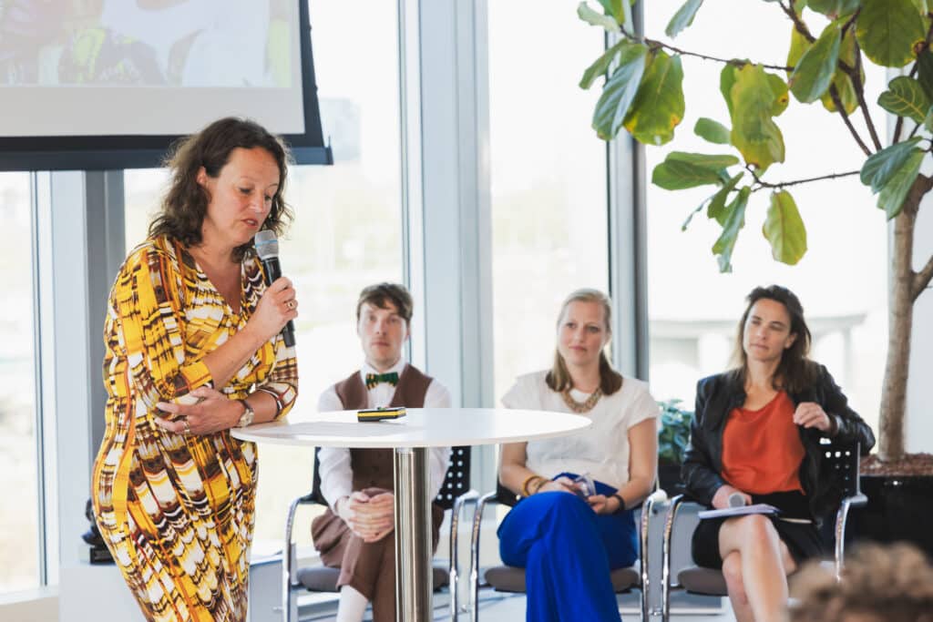 Eventfotografie Albert Schweitzer Prijs: Spreker op podium tijdens evenement. Publiek luistert aandachtig. Joep van Drunen Photography